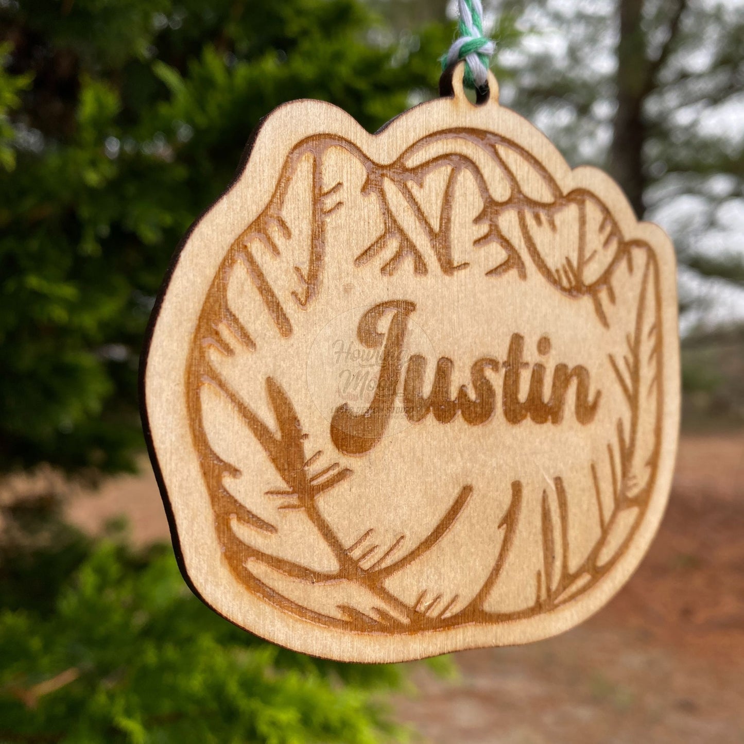 Left side view of Personalized cabbage ornament hanging from a tree with green & white twine. Made by Howling Moon Laser Design in Virginia, USA