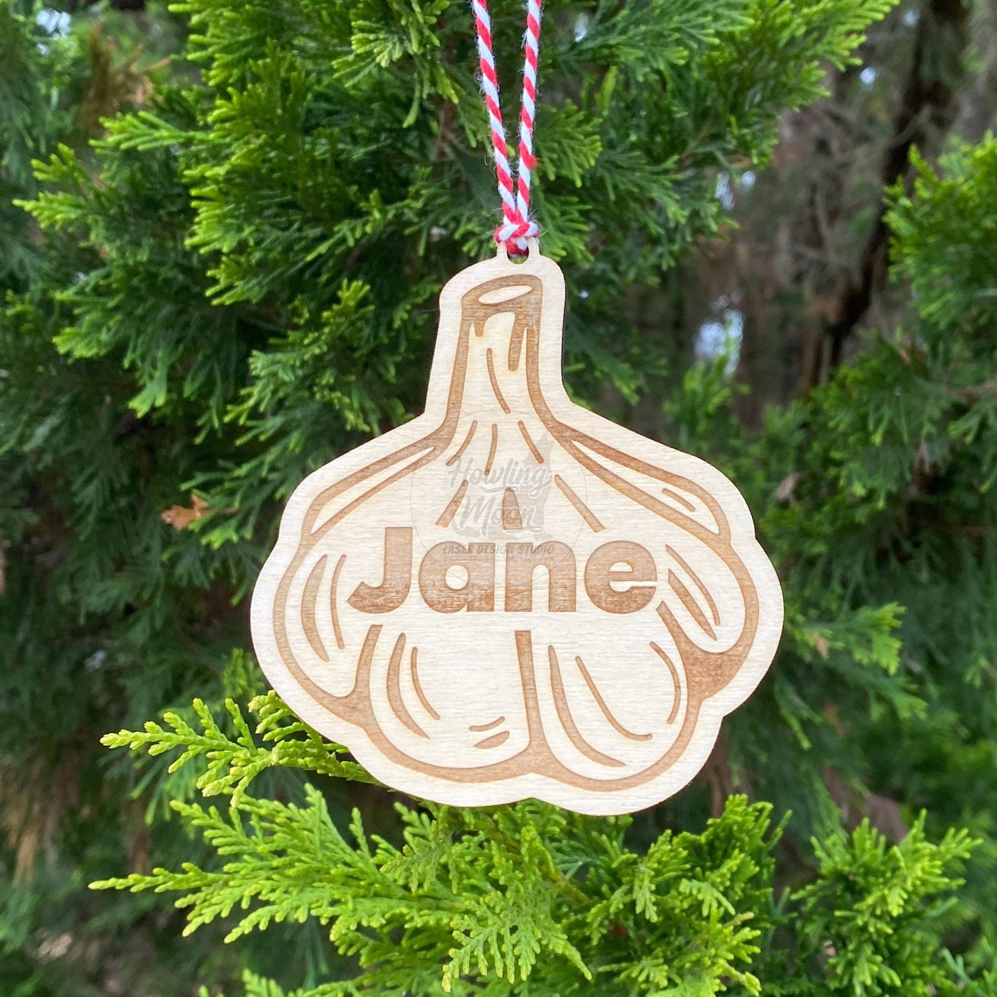Personalized garlic ornament hangs from a tree branch with red & white twine. Handcrafted by Howling Moon Laser Design Studio in Virginia, USA